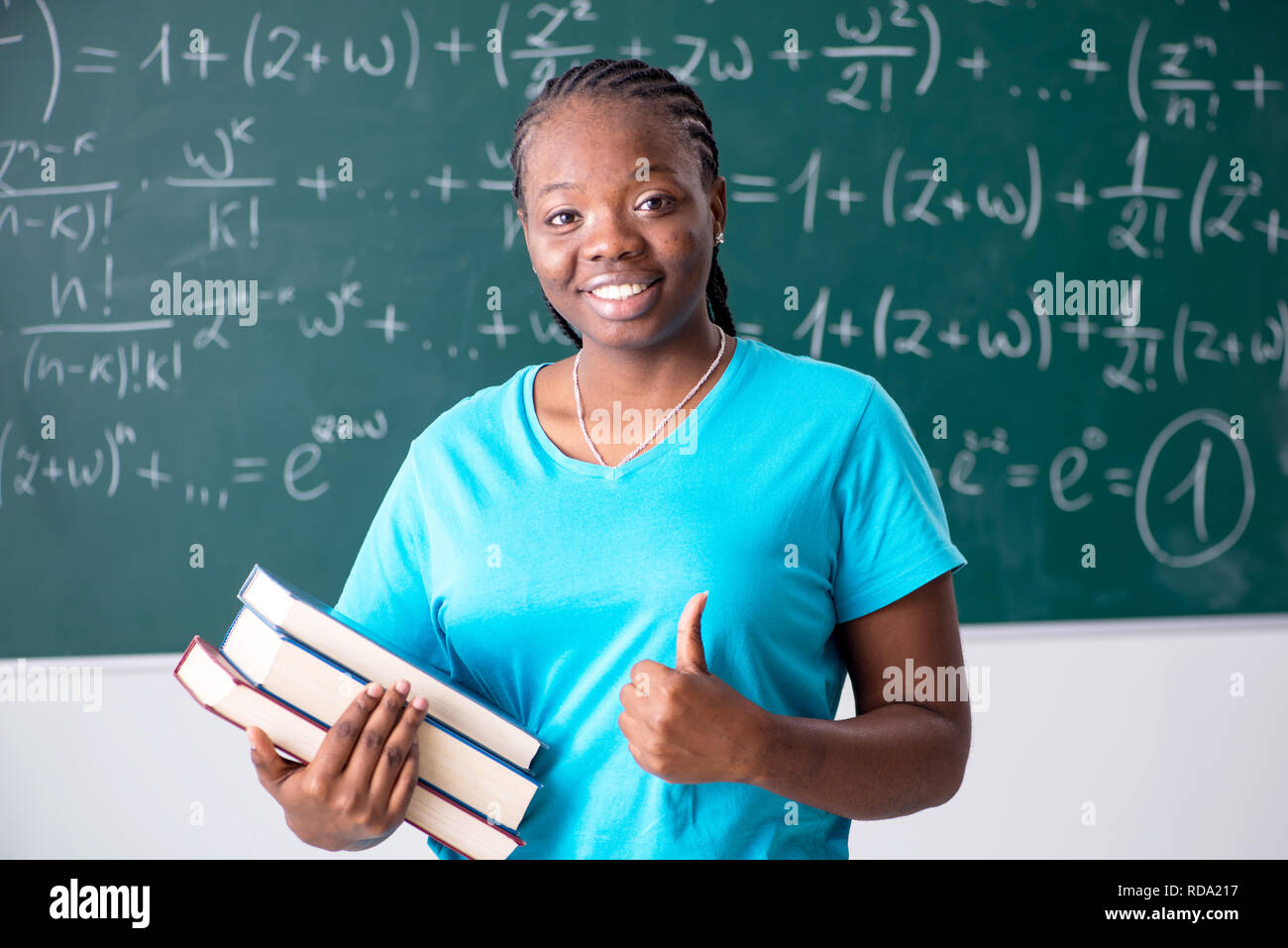 Black female student in front of chalkboard Stock Photo - Alamy