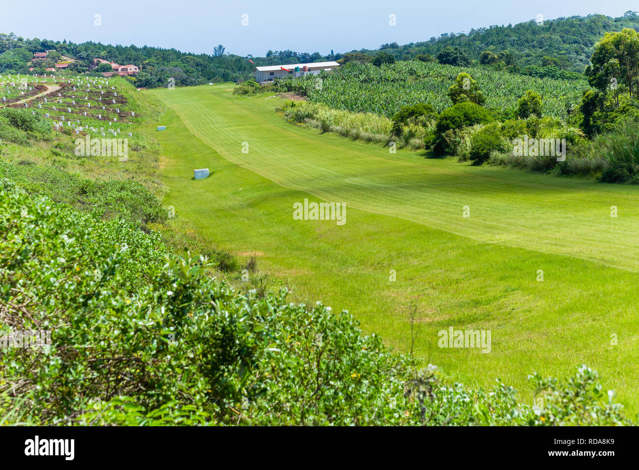 Grass Airfield runway for light planes  among countryside farmlands. Stock Photo