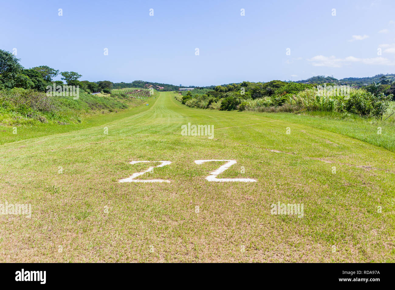 Airfield grass airstrip runway in countryside for light planes among farmland landscape. Stock Photo