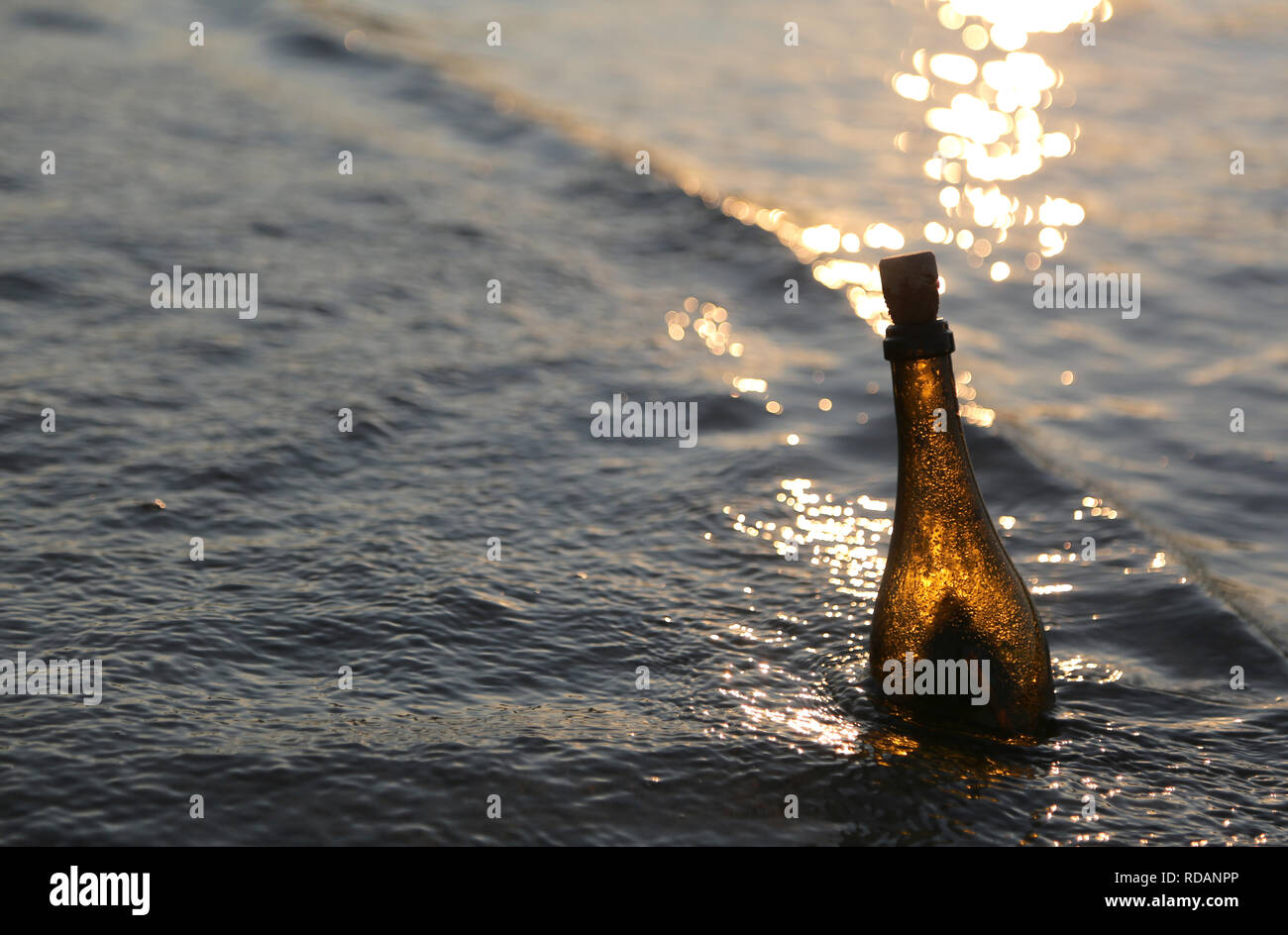 bottle with the secret message in the sea at sunset in the summer Stock ...