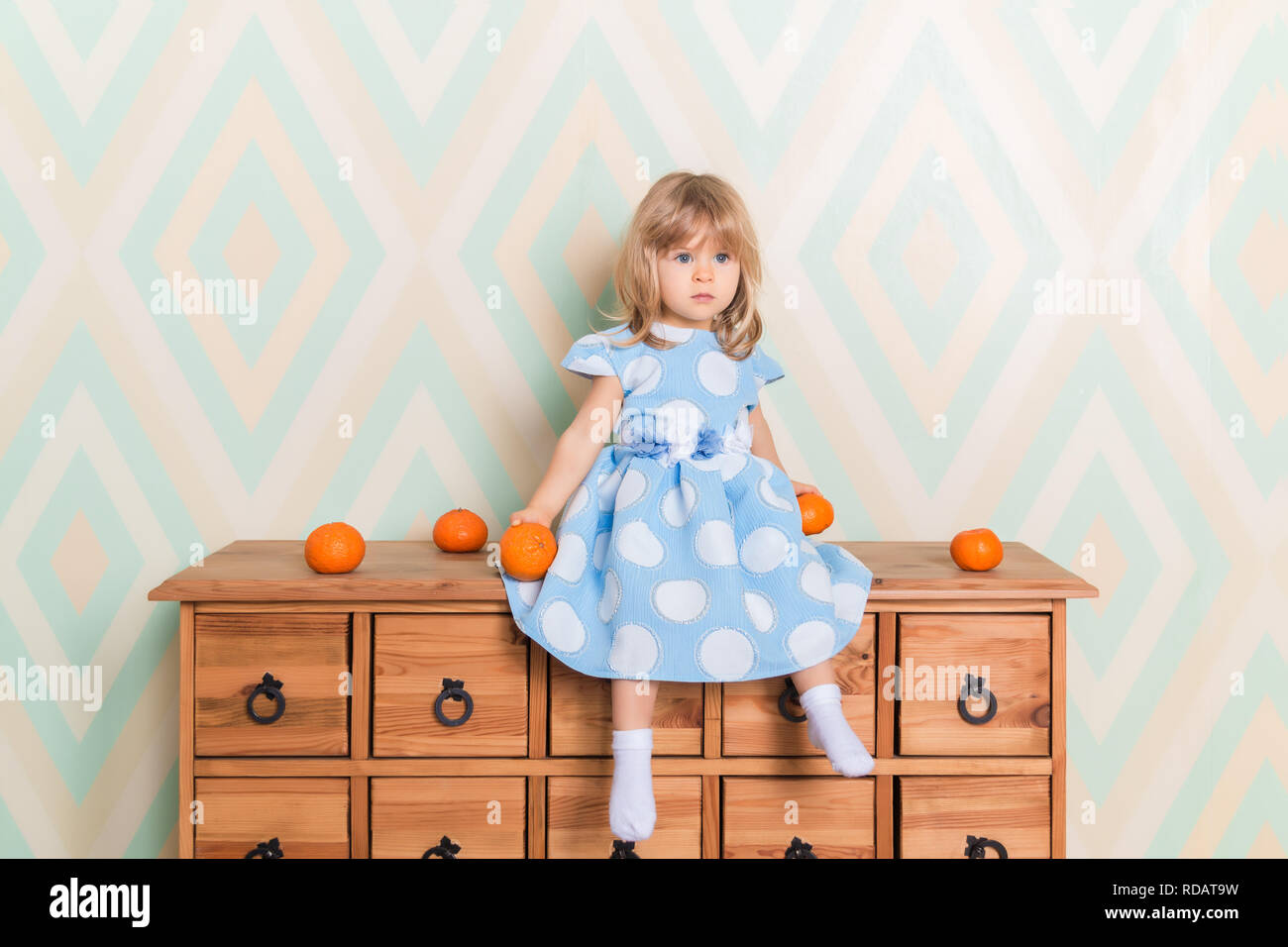 Toddler Child Baby Girl In Light Blue Dress Seriously Sitting On