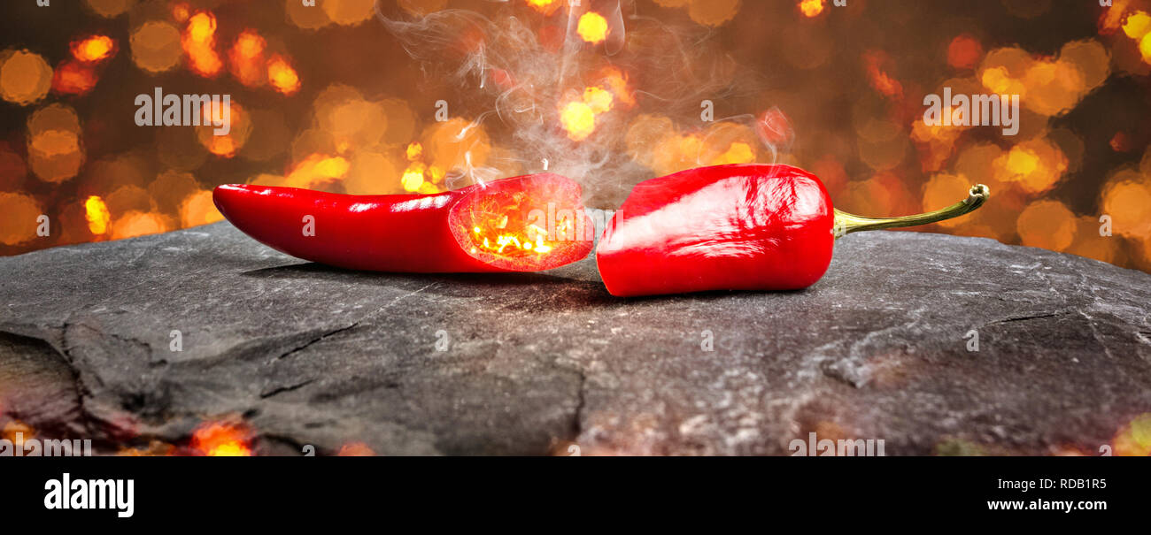 Hot chili pepper surrounded by embers and smoke Stock Photo