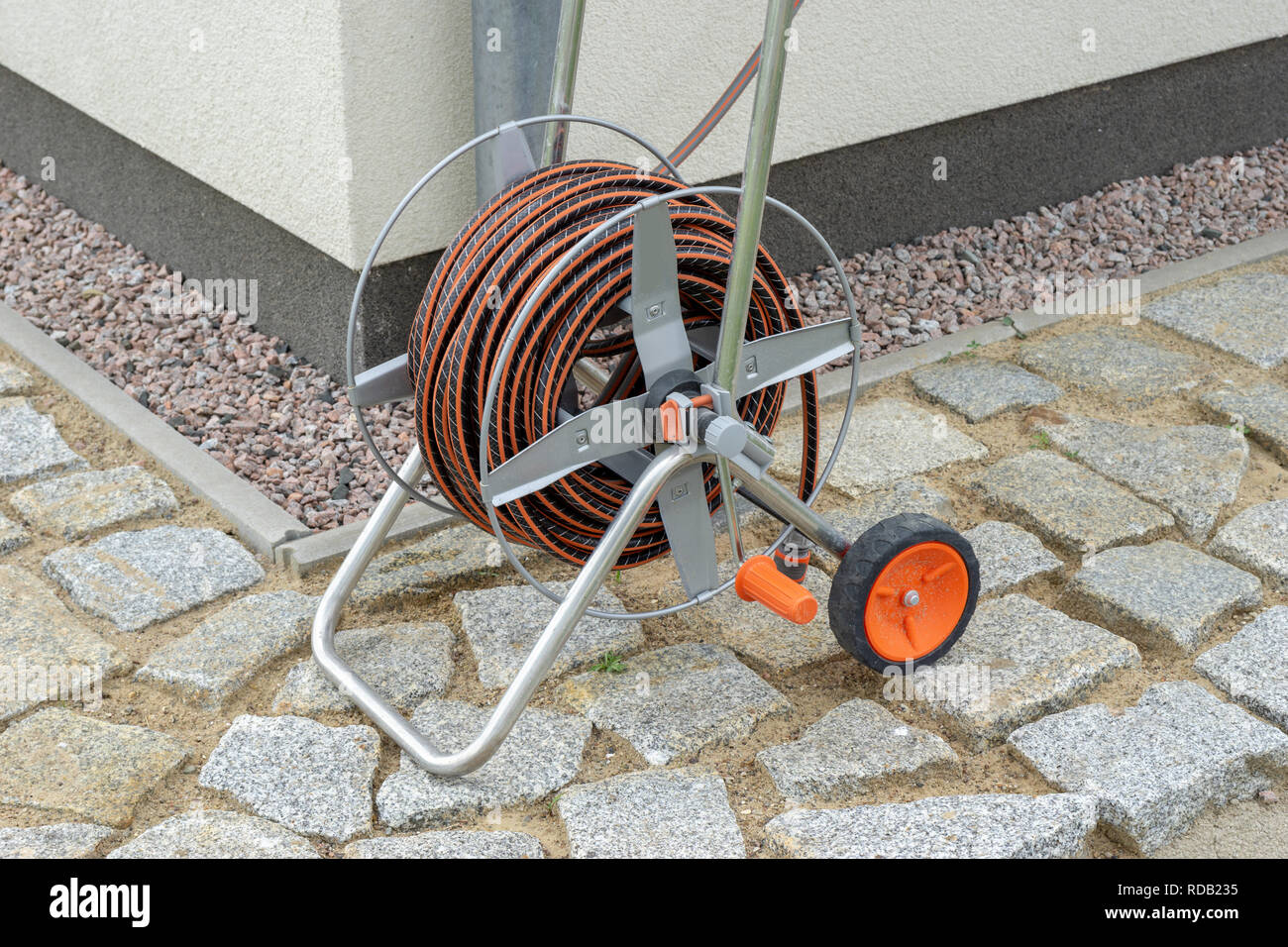 Wind up hose reel beside a rain water tank in a back yard garden Stock  Photo - Alamy