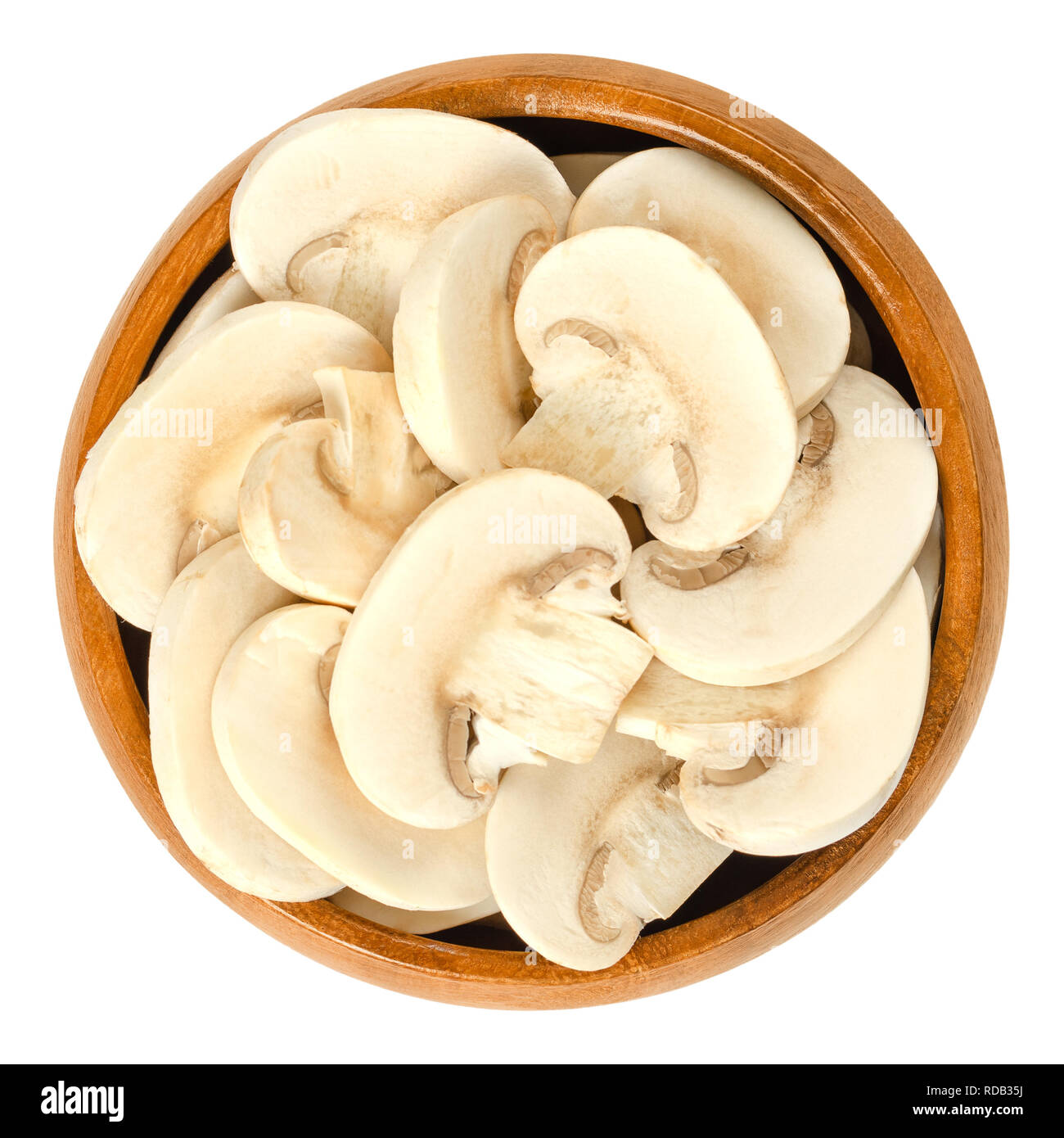 Sliced white champignon mushrooms in wooden bowl. Agaricus bisporus, also called common, button, cultivated or table mushroom. Stock Photo