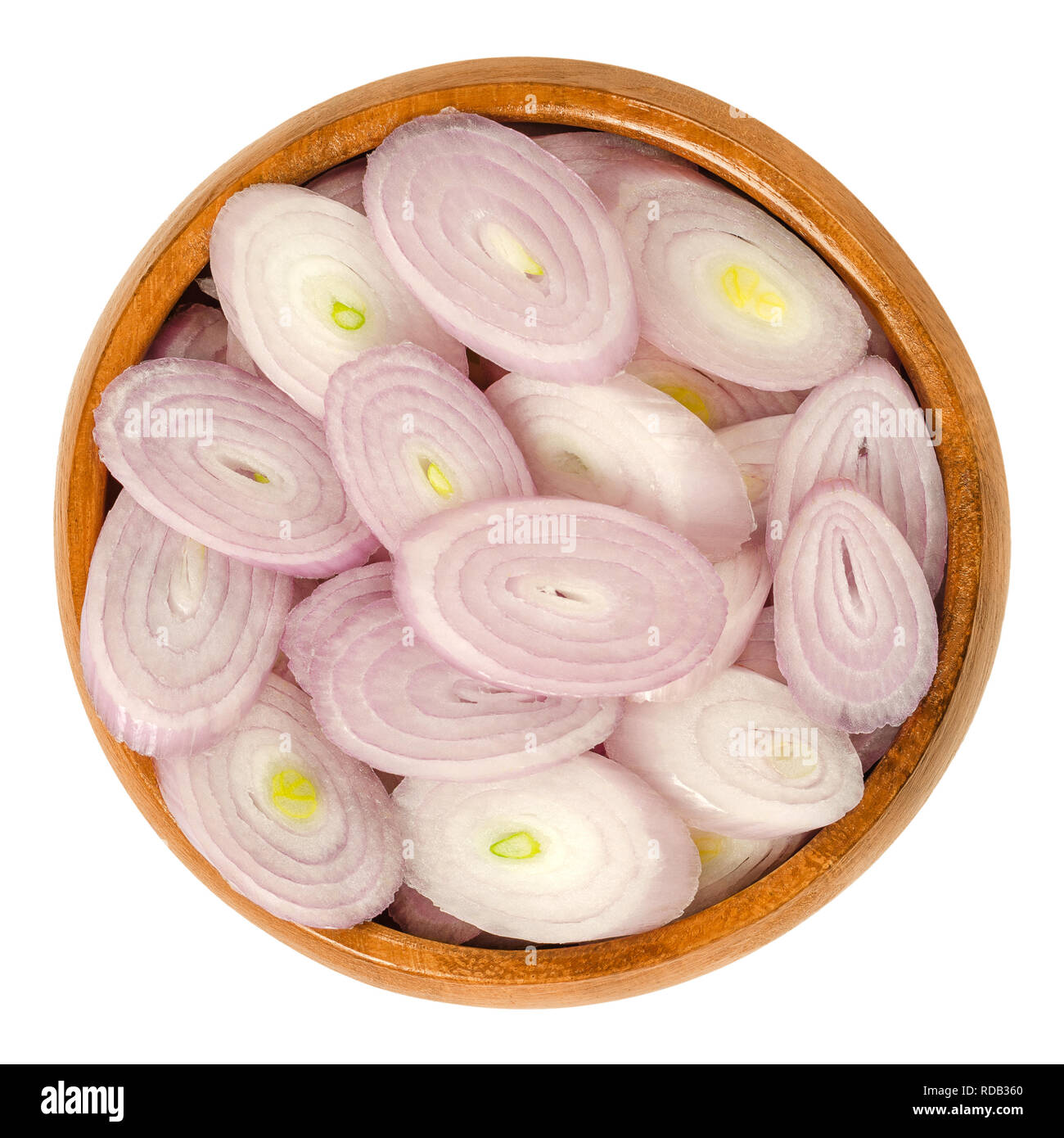 Sliced shallots in wooden bowl. Chopped. Rings. Type of onion and variety of Allium cepa. Purple, edible, raw, organic, vegan, plant. Stock Photo