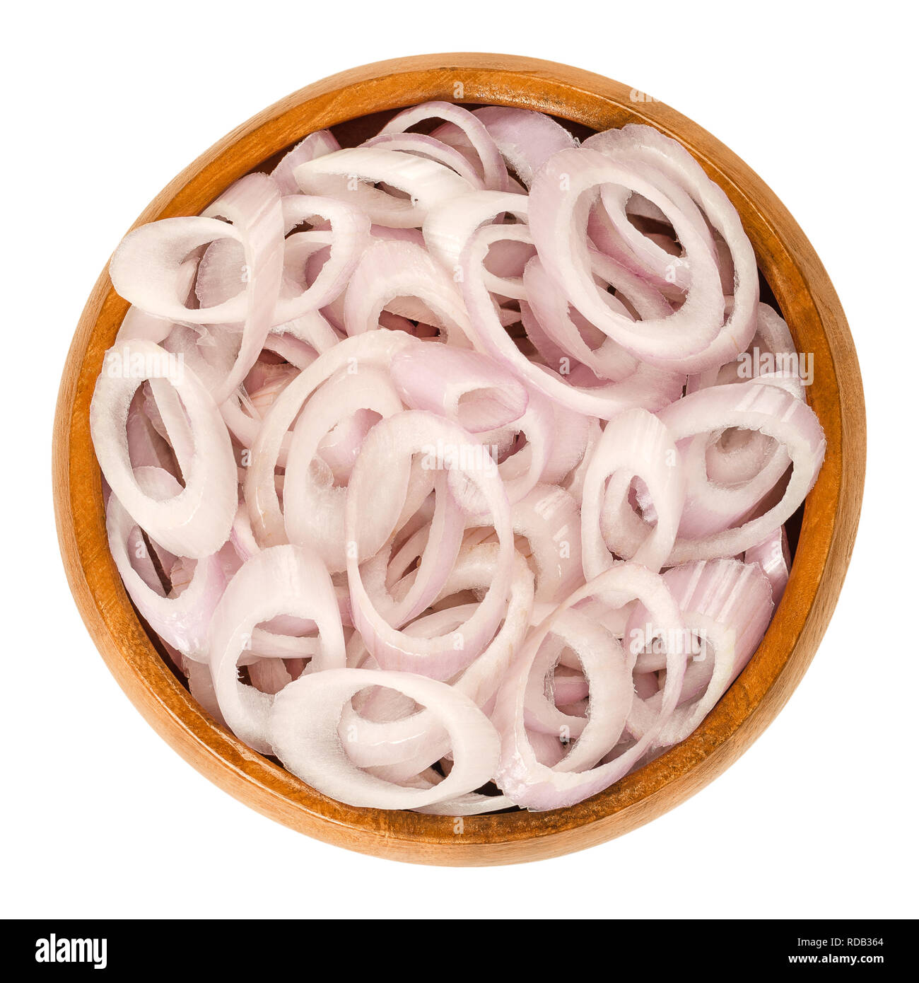 Rings of sliced shallots in wooden bowl. Chopped. Type of onion and variety of Allium cepa. Purple, edible, raw, organic, vegan, plant. Stock Photo