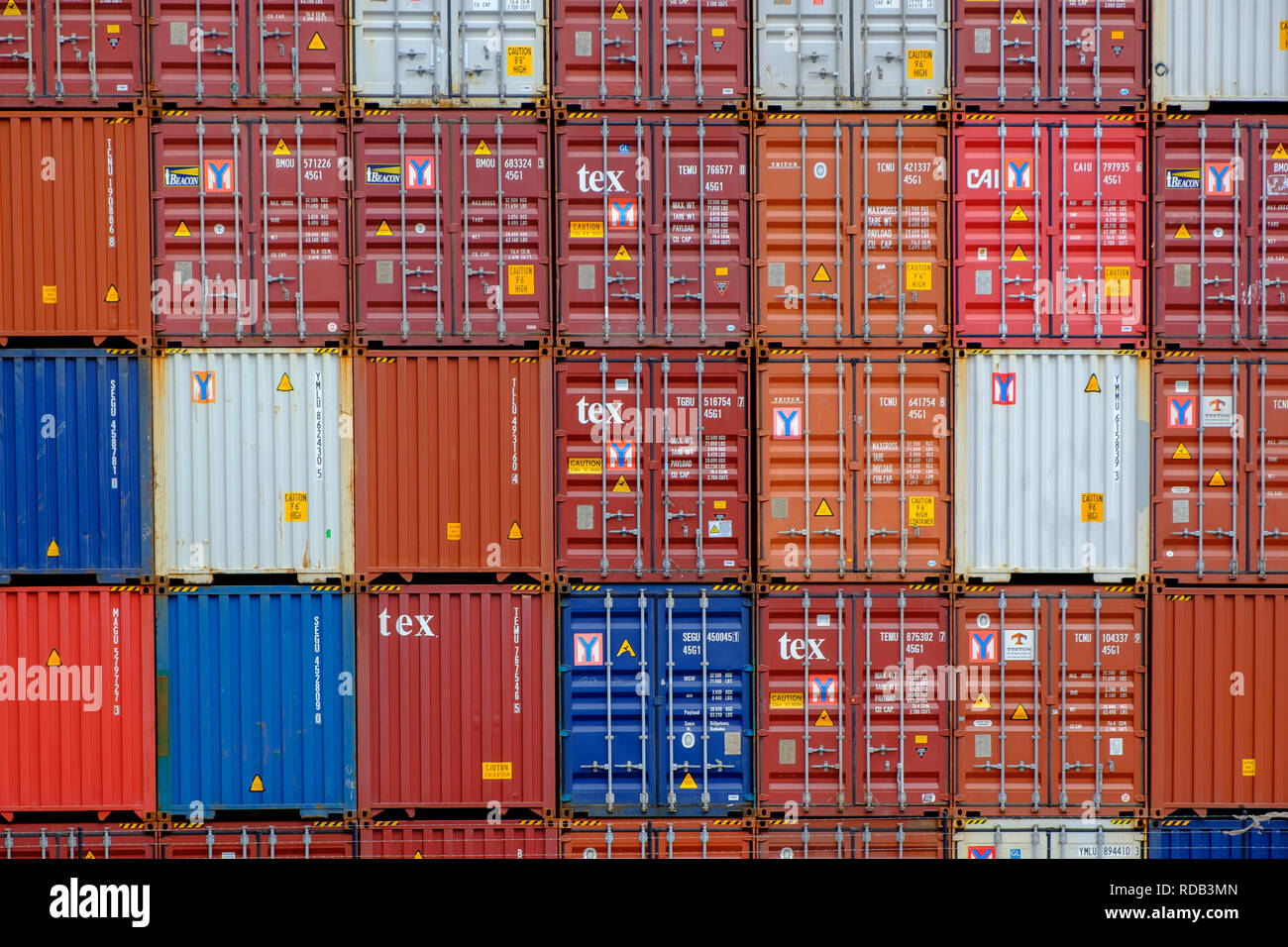 End on view of a stack of shipping containers stacked in a yard in