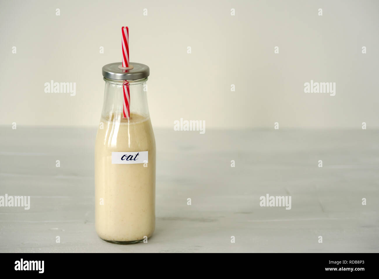 Glass bottle of oat milk on white background. Stock Photo