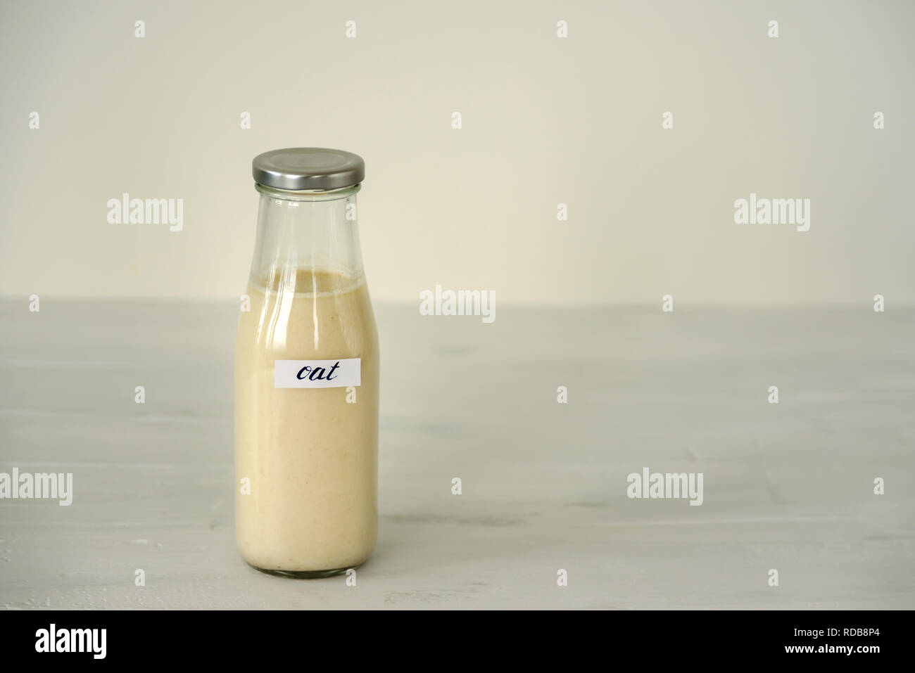 Glass bottle of oat milk on white background. Stock Photo