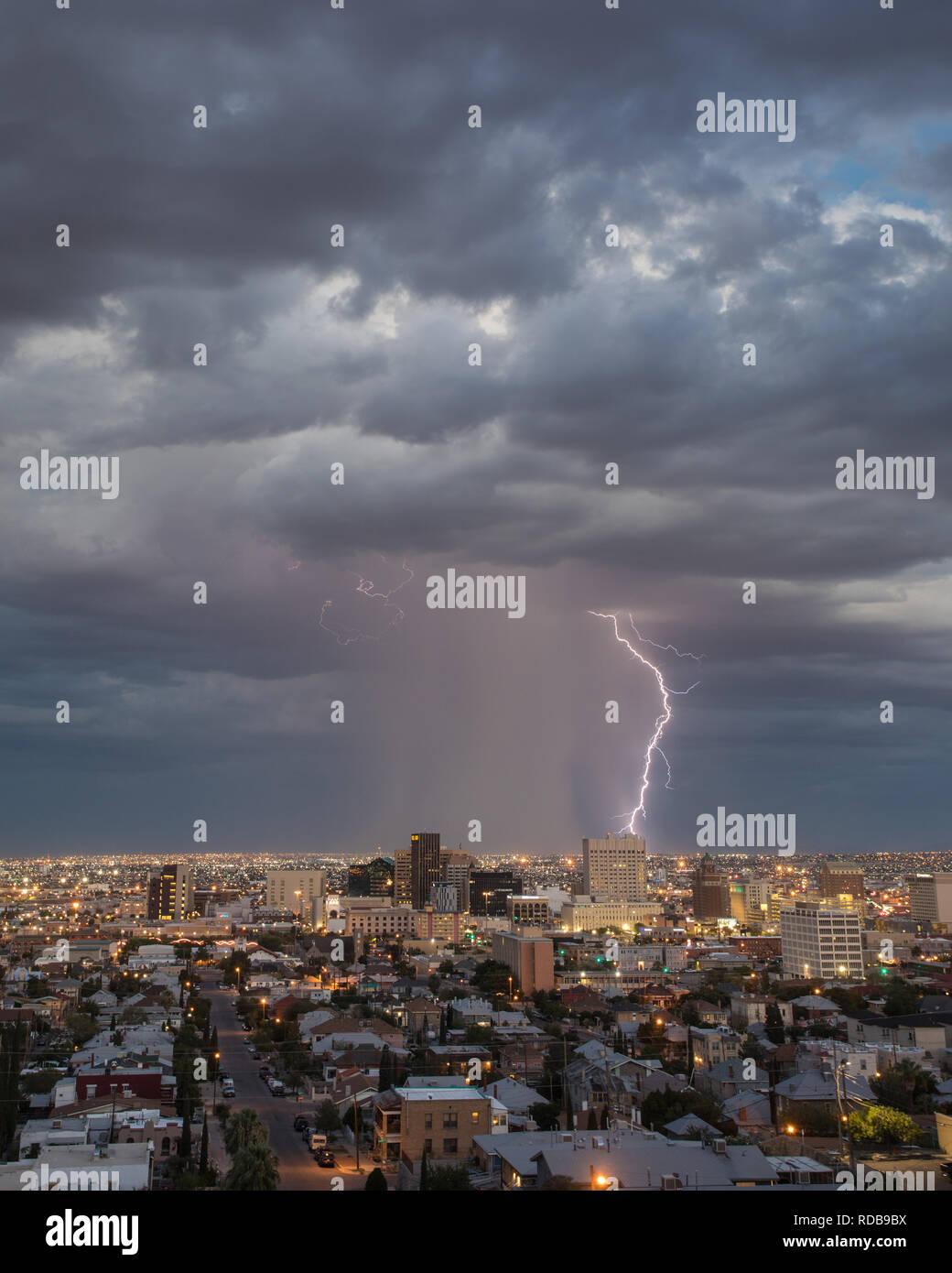 Cloud to ground lightning strikes an urban landscape behind the El Paso