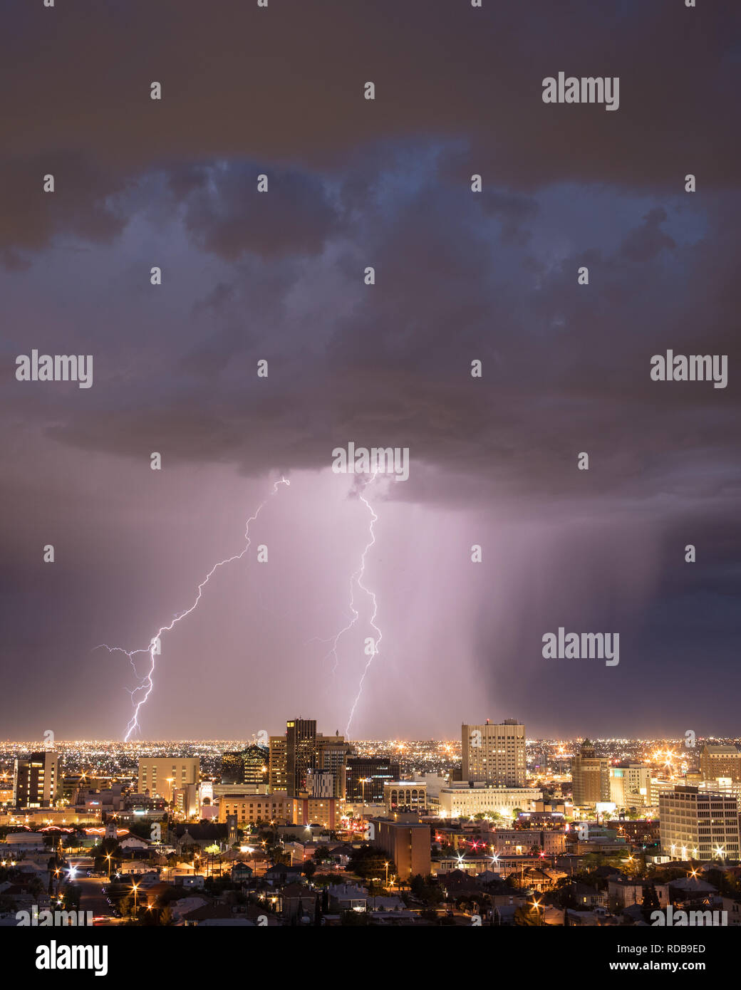Cloud to ground lightning strikes an urban landscape behind the El Paso
