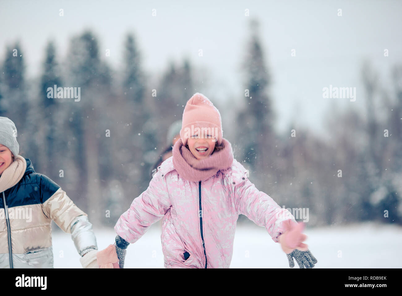 Portrait of little adorable girl in snow sunny winter day Stock Photo