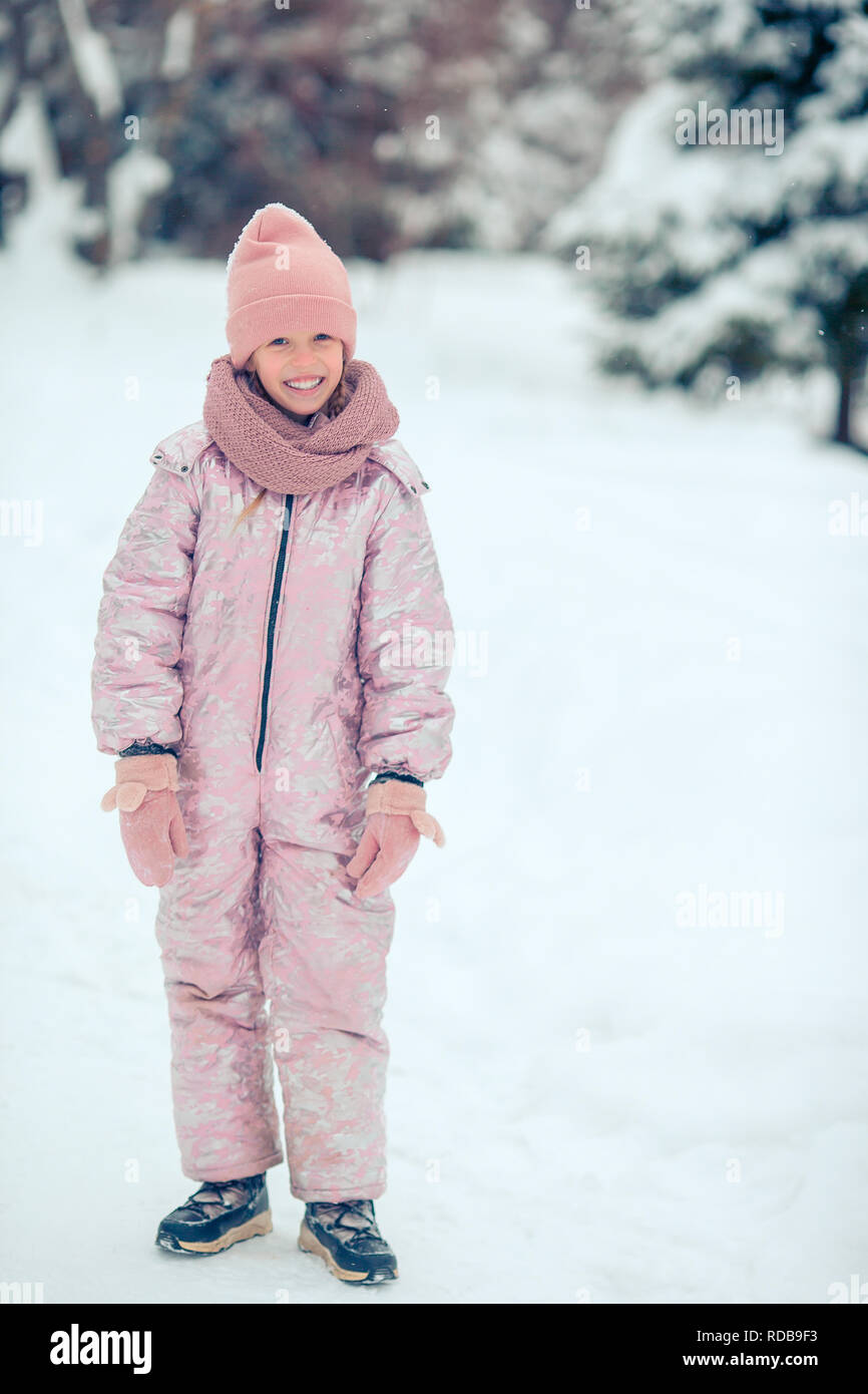 Portrait of little adorable girl in snow sunny winter day Stock Photo