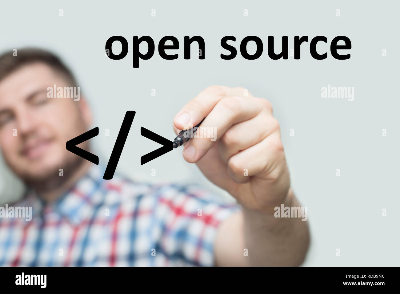 startup programmer writes open source on a glass board with a black marker Stock Photo
