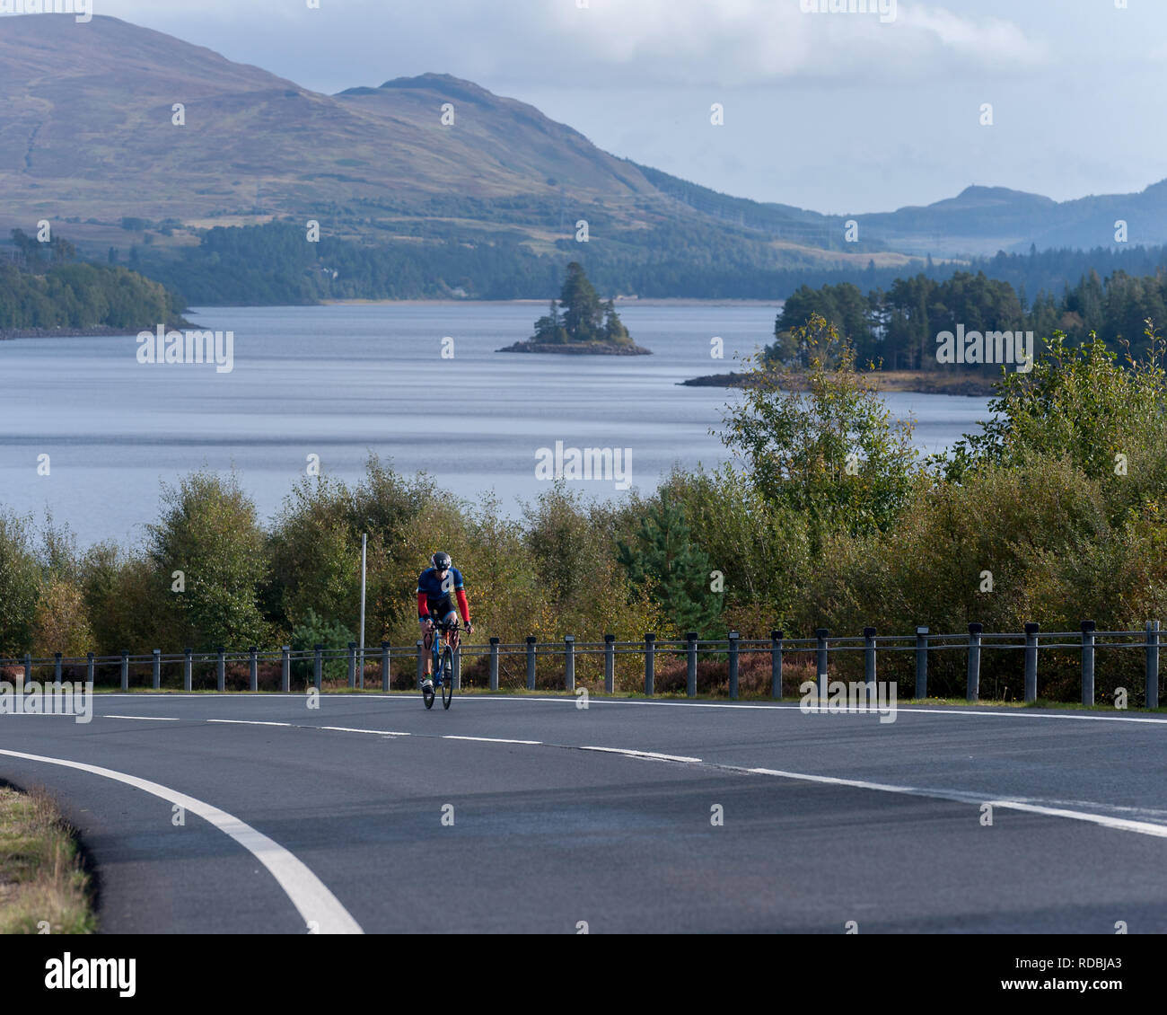 Cyclist on the A86 passing loch laggan Highlands Scotland Stock Photo