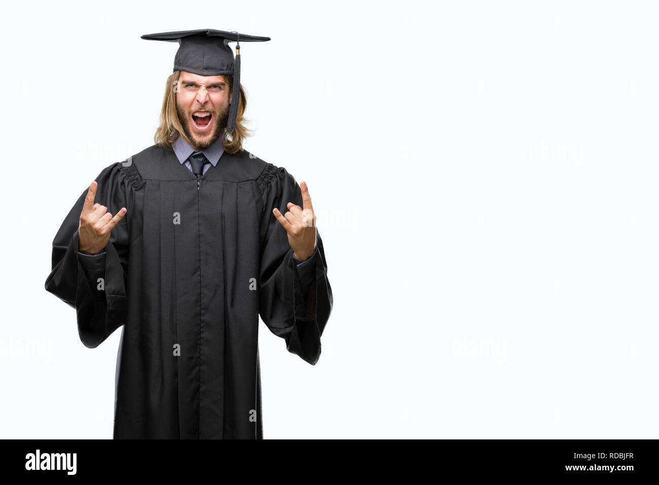 Young handsome graduated man with long hair over isolated background shouting with crazy expression doing rock symbol with hands up. Music star. Heavy Stock Photo
