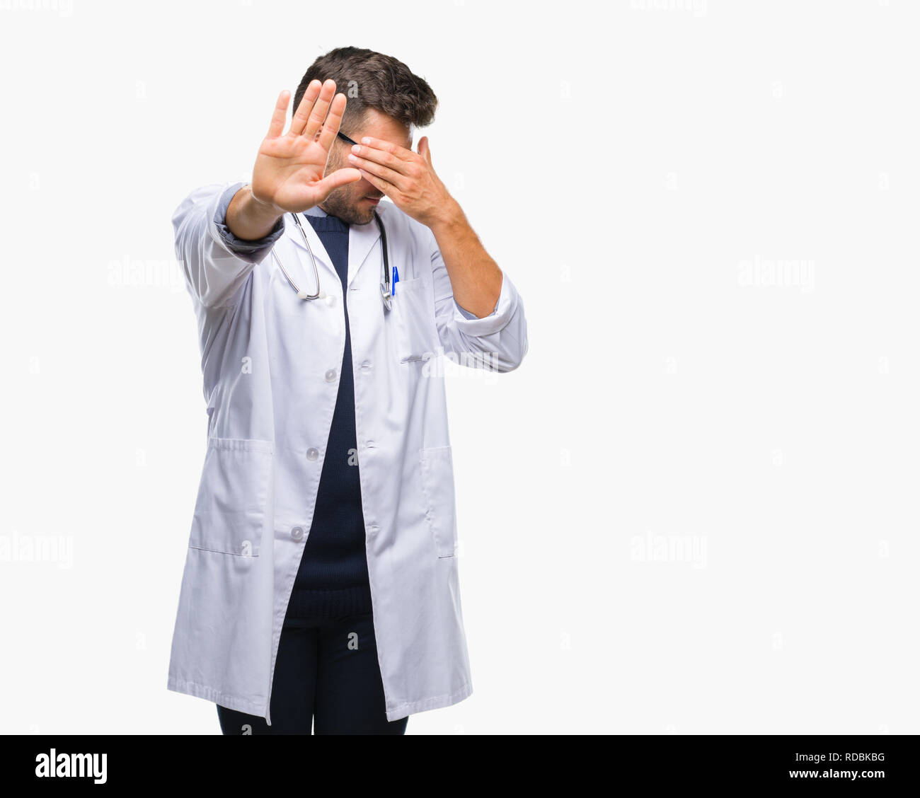 Young handsome doctor man over isolated background covering eyes with hands and doing stop gesture with sad and fear expression. Embarrassed and negat Stock Photo