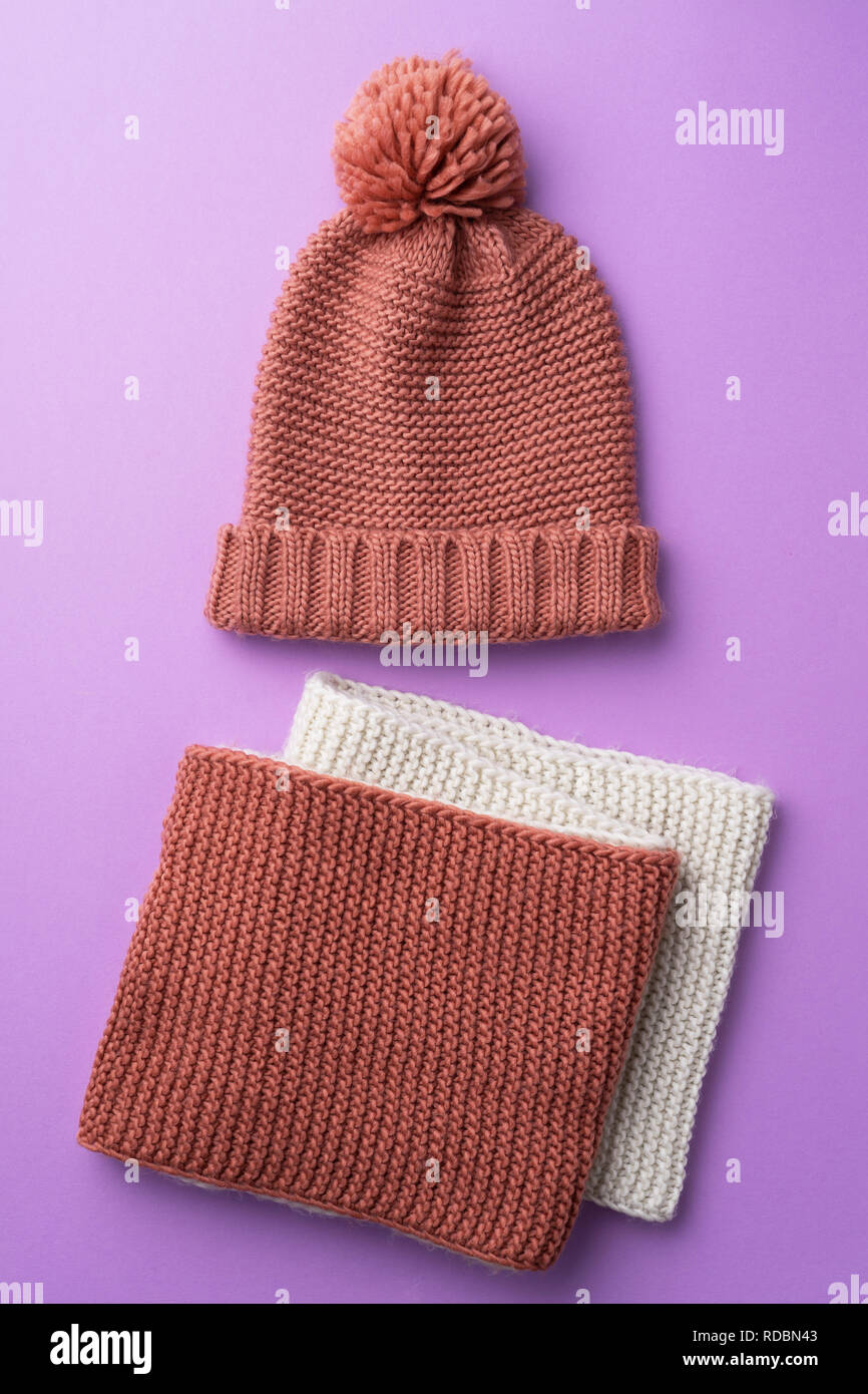 Knit winter hat and scarf over purple background Stock Photo