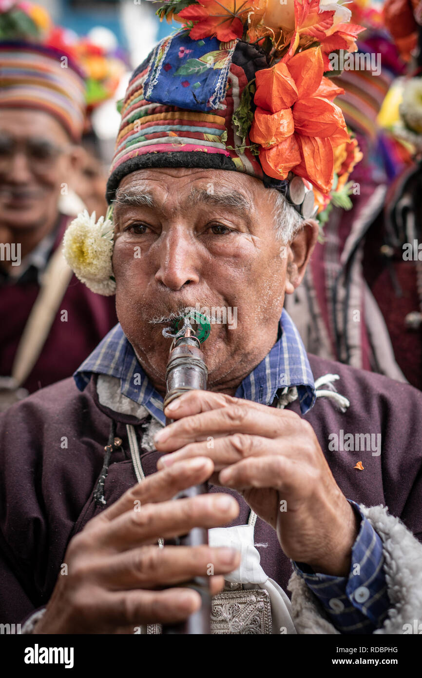 Ladakh, India - September 4, 2018: Native man with traditional hat playing on flute during festival in Ladakh. Illustrative editorial. Stock Photo