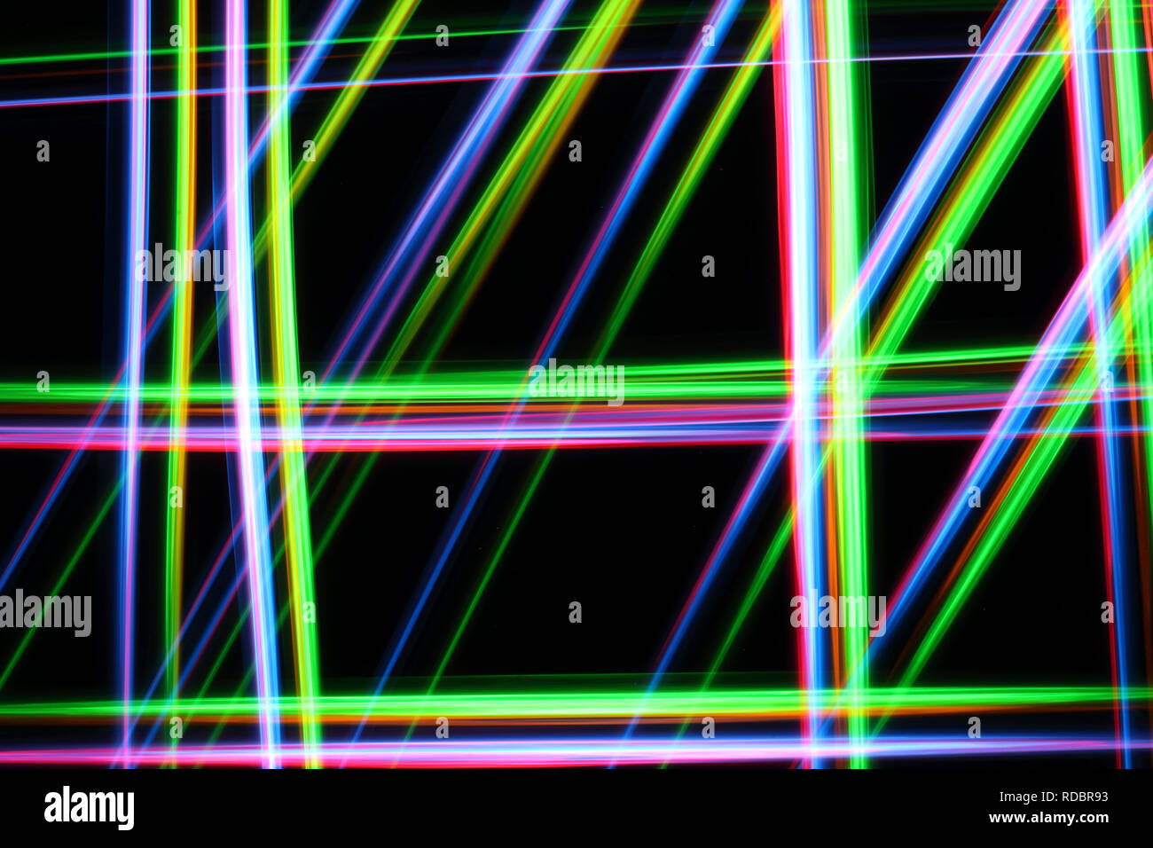 A colorful and glowing light painting abstract image with red, green, blue and yellow blurry lines over a black background, creating a net Stock Photo