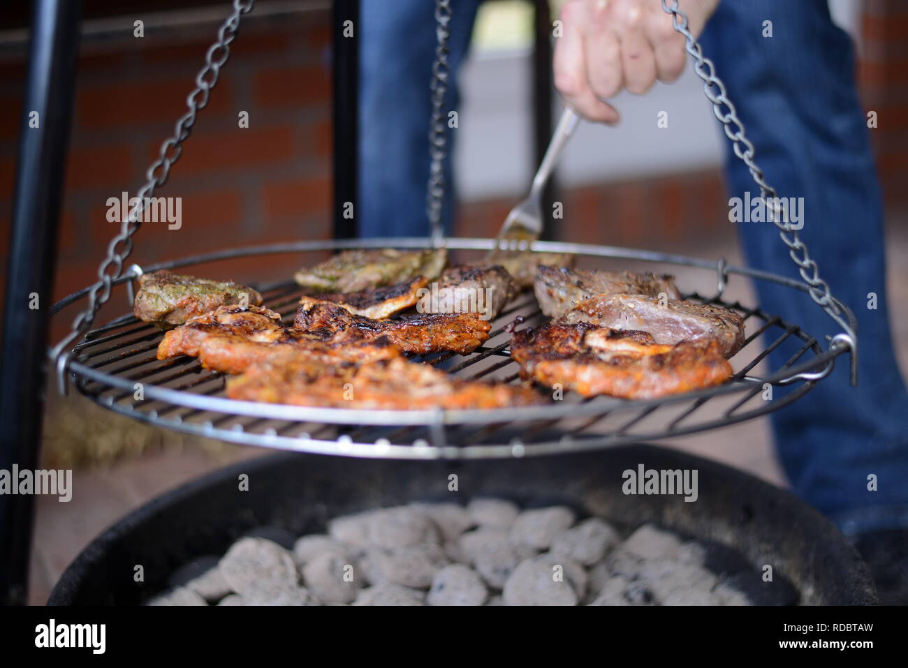 Lecker Rinder Steak und ungesundes Schweinefleisch grillen über Grillkohle auf der Gartenparty, heißes Grillfleisch von modernem Lagerfeuer Stock Photo