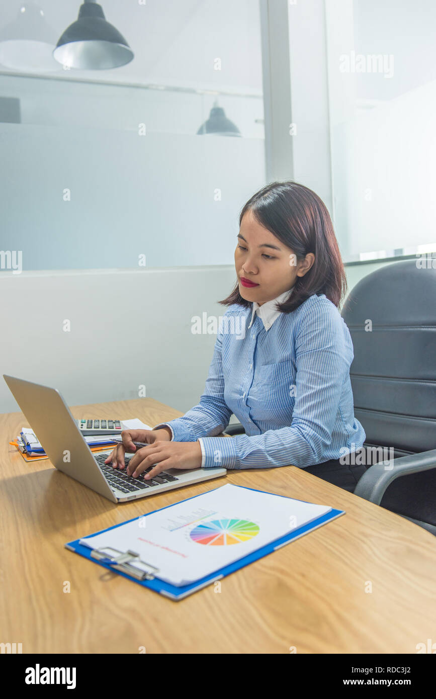 Asian staff working on laptop Stock Photo - Alamy