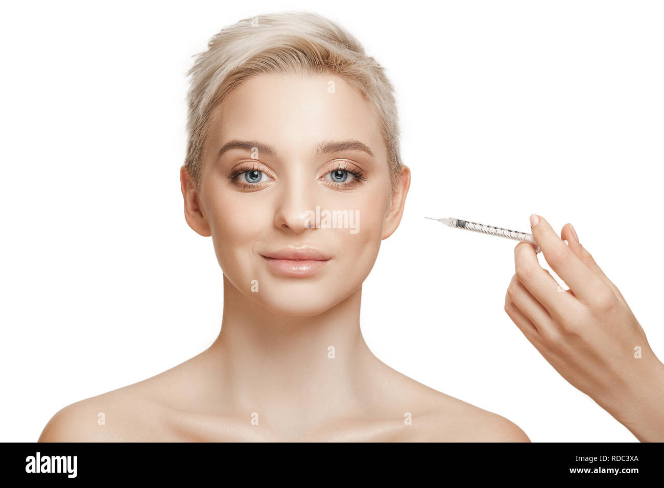People, Lips, cosmetology, plastic surgery and beauty concept - beautiful young woman face and hand with syringe making injection Stock Photo