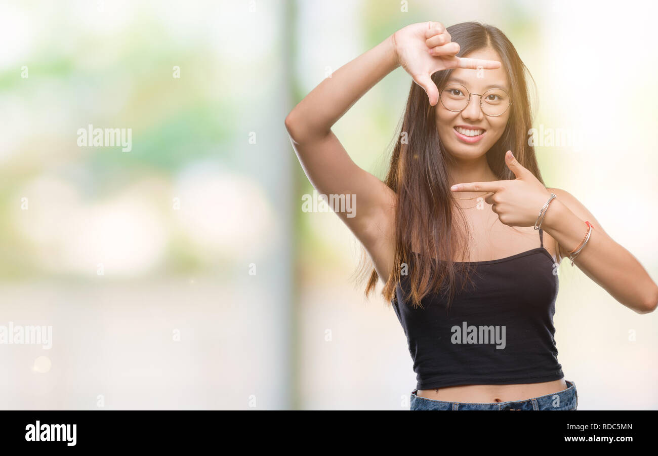 Young asian woman wearing glasses over isolated background smiling ...