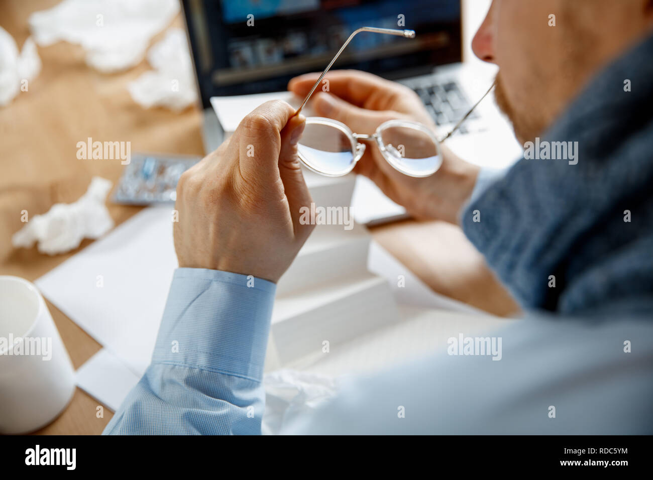 Sick man with pills working in office, businessman caught cold, seasonal flu. Pandemic influenza, disease prevention, illness, virus, infection, temperature, fever and flu concept Stock Photo