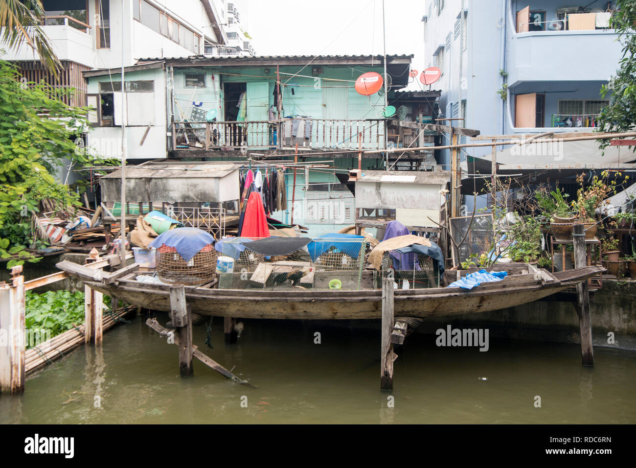 a House with fishingboat at the Khlong Banglamphu and Rop Krung at the Phra Athit Road in Banglamphu in the city of Bangkok in Thailand in Southeastas Stock Photo