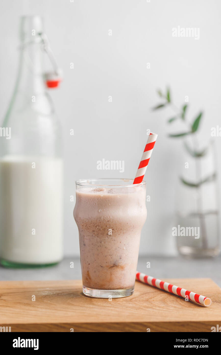Cold fitness shake is made from milk, protein, cocoa and ice cubes. The