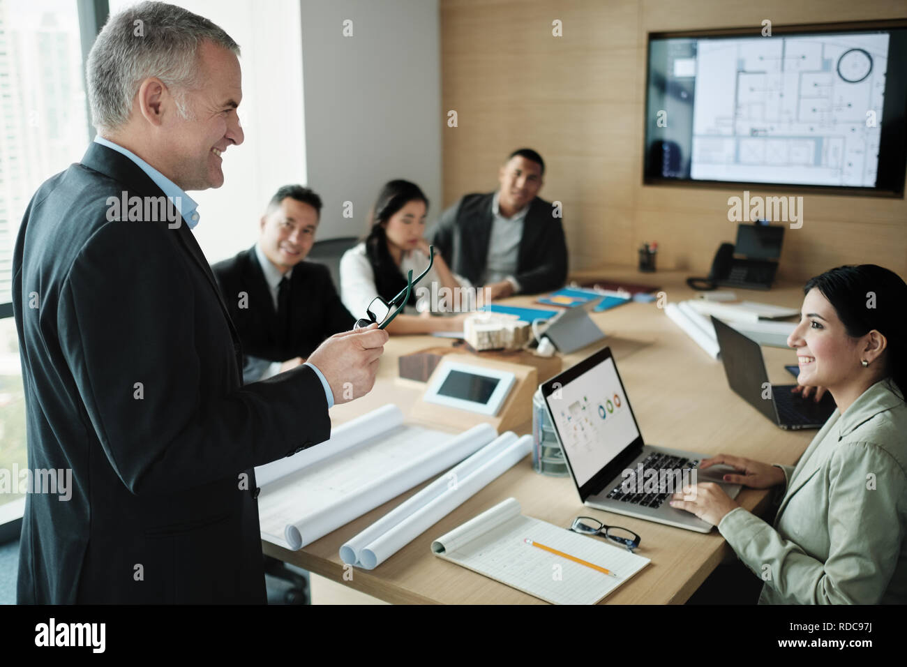Architect Showing Miniature Building At Business Meeting With Client Stock Photo