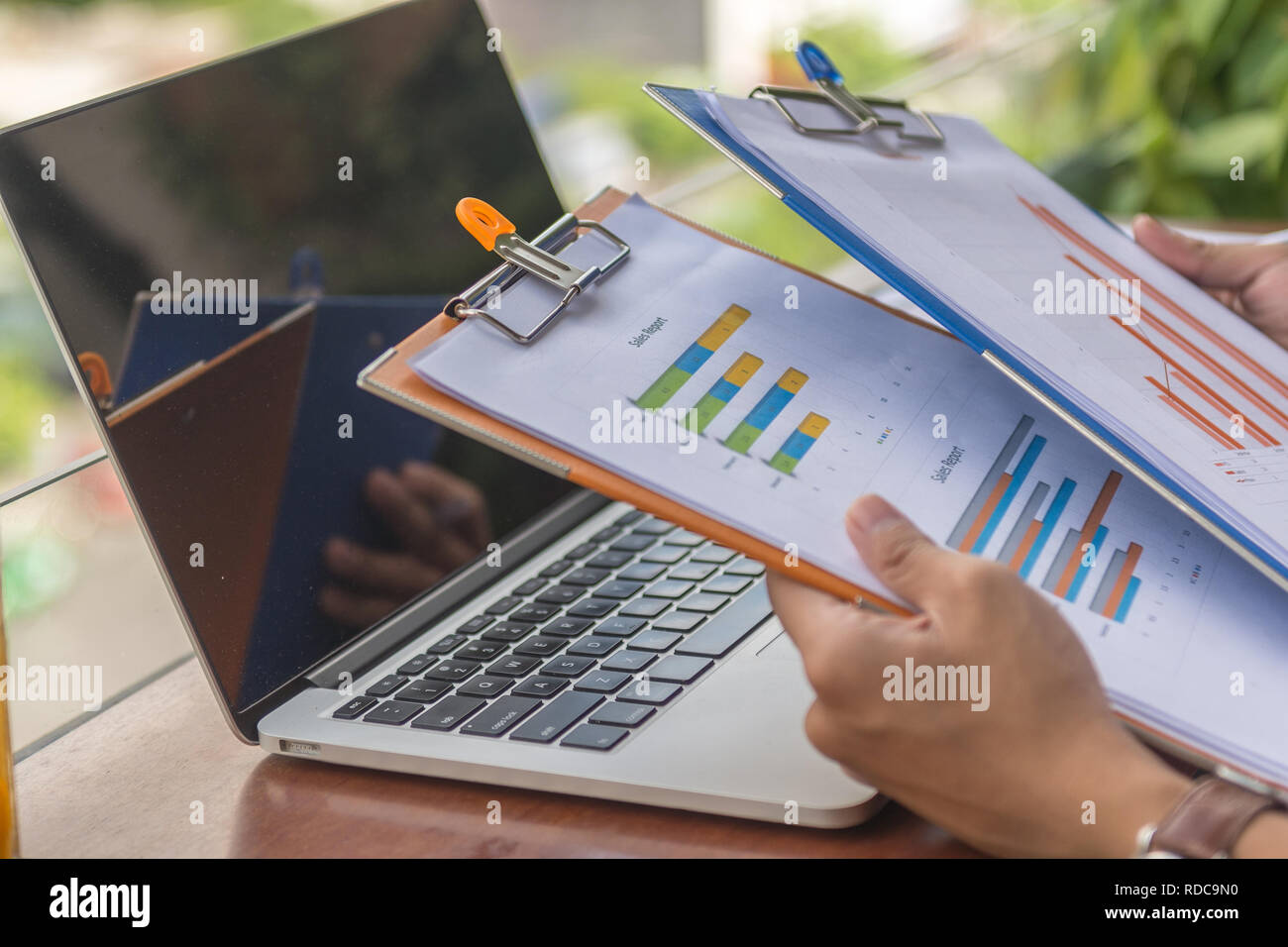 Man hand holding sales reports Stock Photo