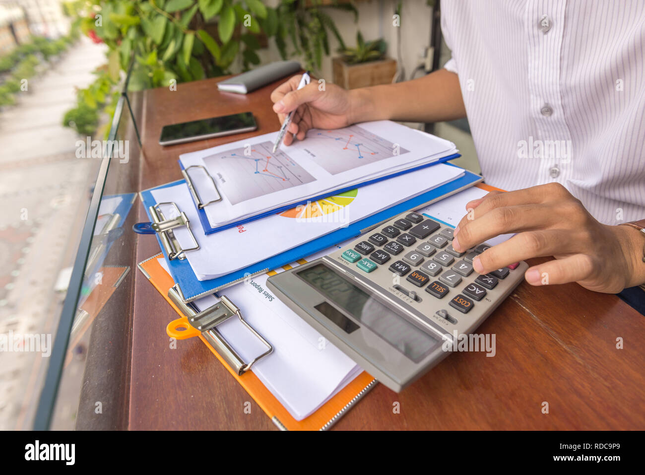 Man hand using calculator to check financial report Stock Photo