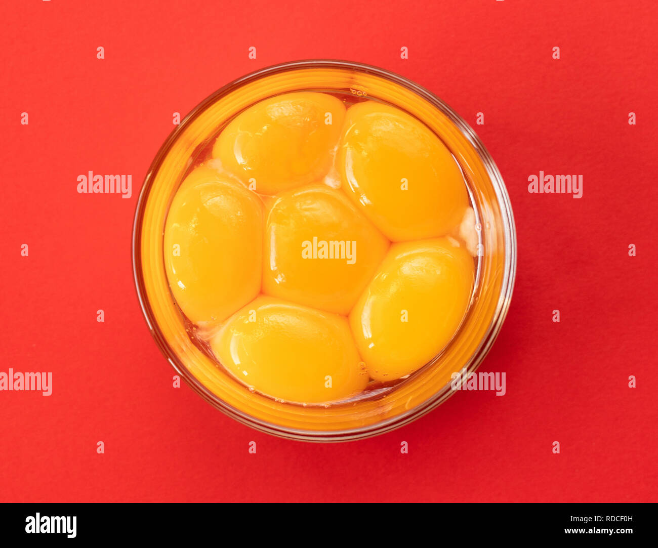 Six raw eggs in a glass bowl with beaters near yolk Image, isolated