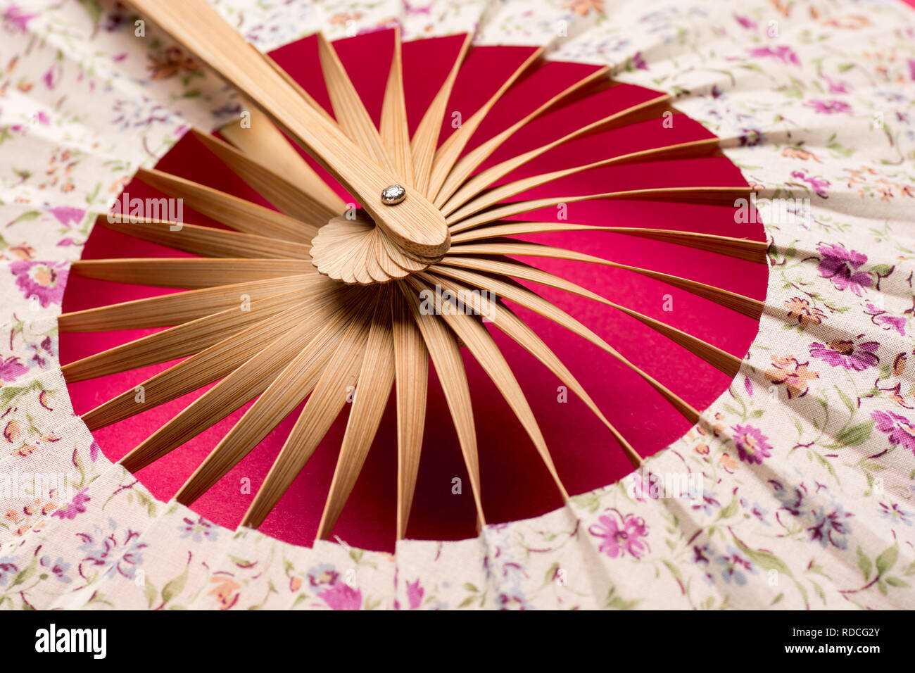 Traditional fan with far eastern motive on red background close up Stock Photo