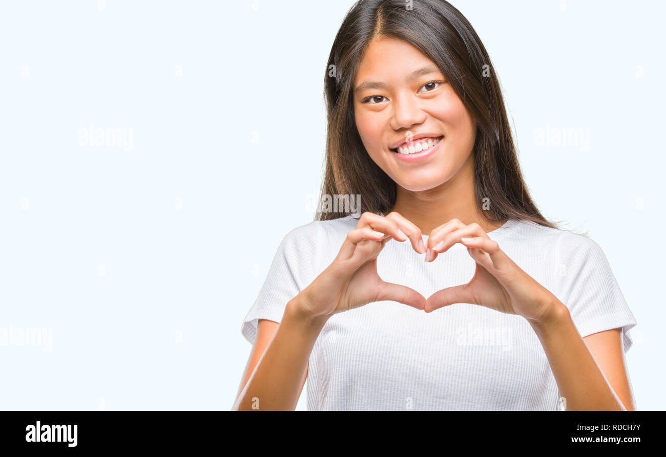 Young asian woman over isolated background smiling in love showing ...