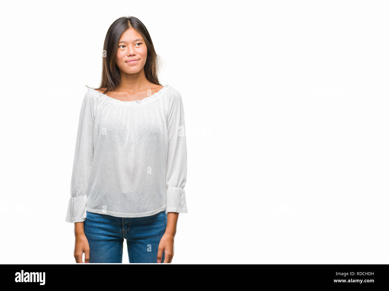 Young asian woman over isolated background smiling looking side and staring away thinking. Stock Photo