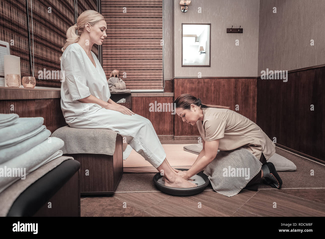 Nice young woman making a bath for feet Stock Photo