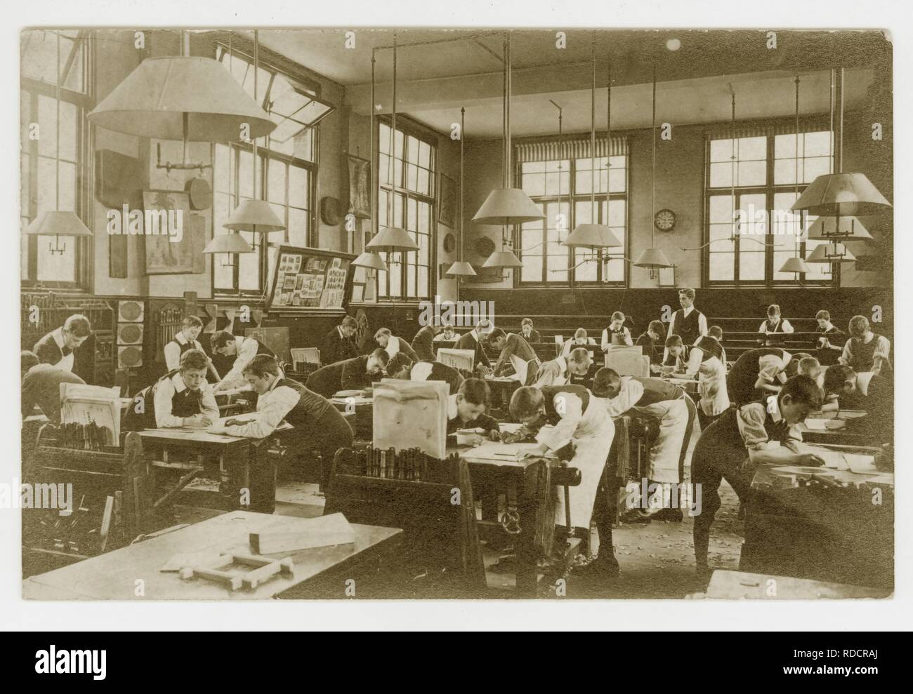 Original early 1900's Edwardian postcard of Edwardian schoolboys drawing plans for woodwork in a classroom, circa 1910, U.K Stock Photo