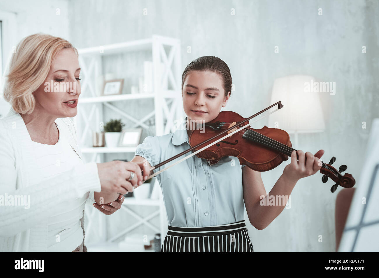 Serious professional music teacher holding a violin bow Stock Photo