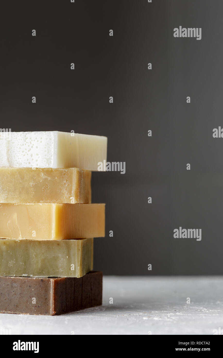 Tower stack of different kinds of handmade soaps over grey background ...