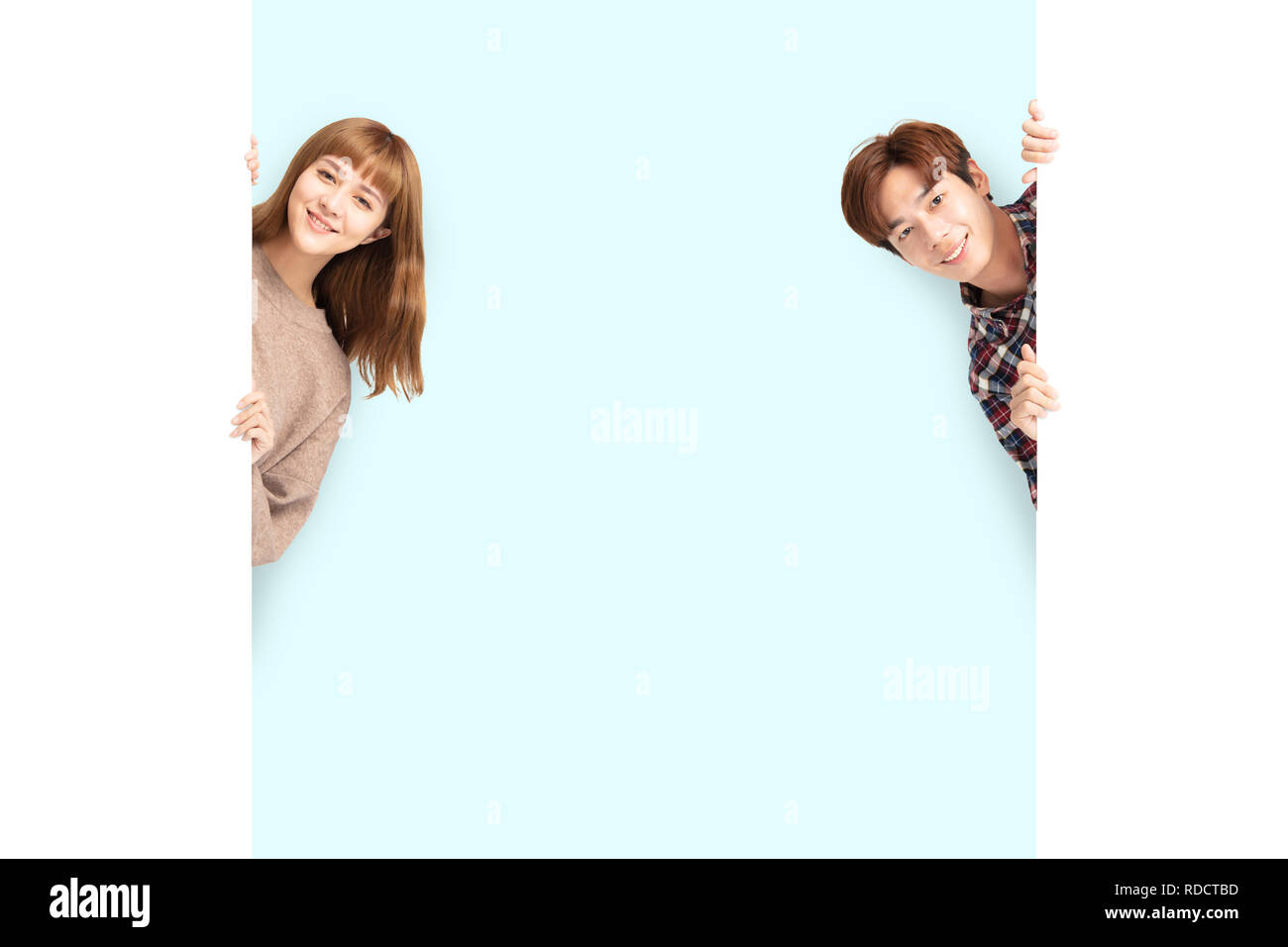 young couple posing  behind blank white board Stock Photo