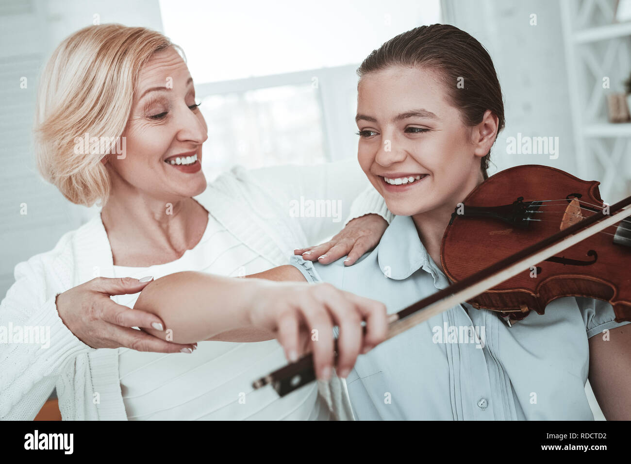 Cheerful happy girl enjoying playing the violin Stock Photo - Alamy