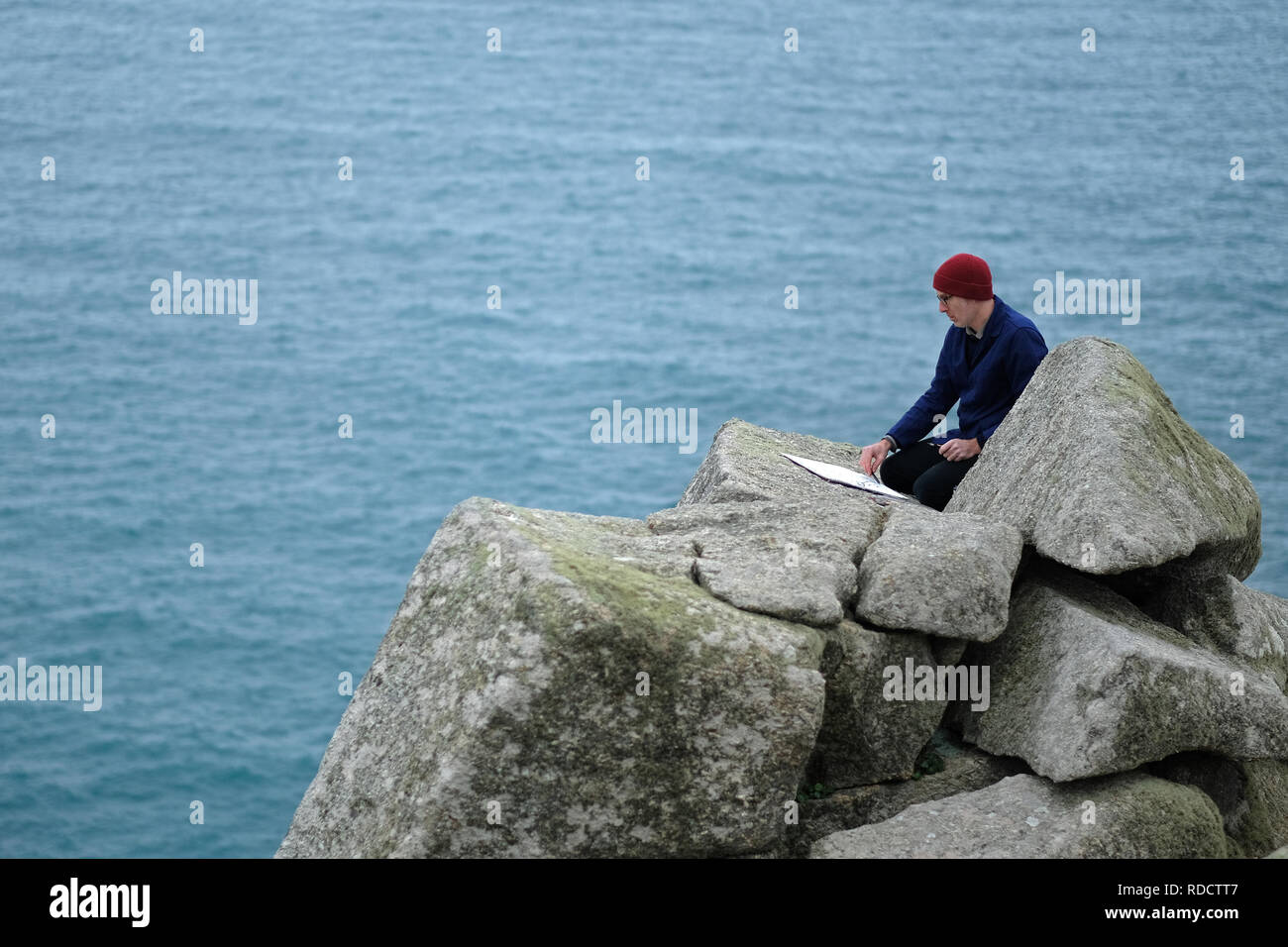 A landscape painter sketching in Cornwall,UK Stock Photo