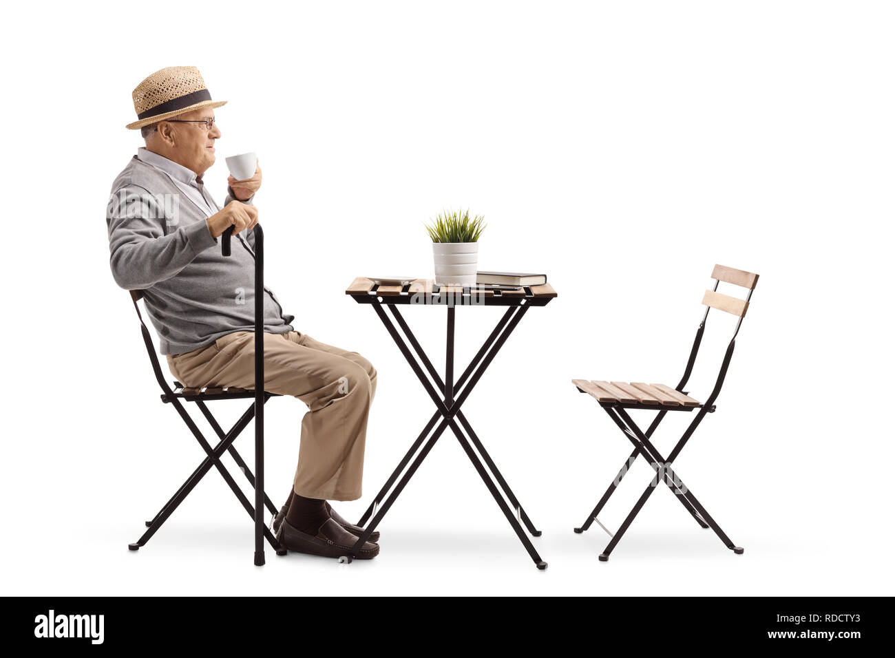 Full length profile shot of a senior man drinking coffee at a table isolated on white background Stock Photo