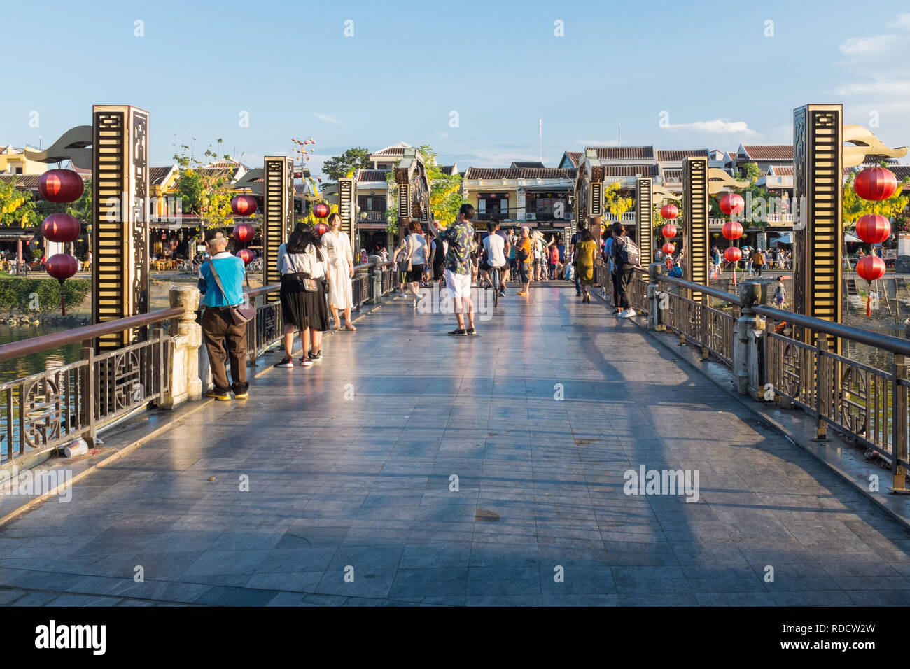 Tourists standing on a bridge over the canal in the Vietnamese city of Hoi An in Quang Nam Province Stock Photo