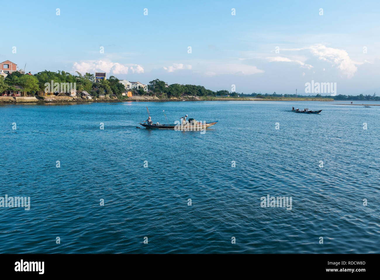 Small fishing boats on the Thu Bon River in the Vietnamese city of Hoi An in Quang Nam Province Stock Photo