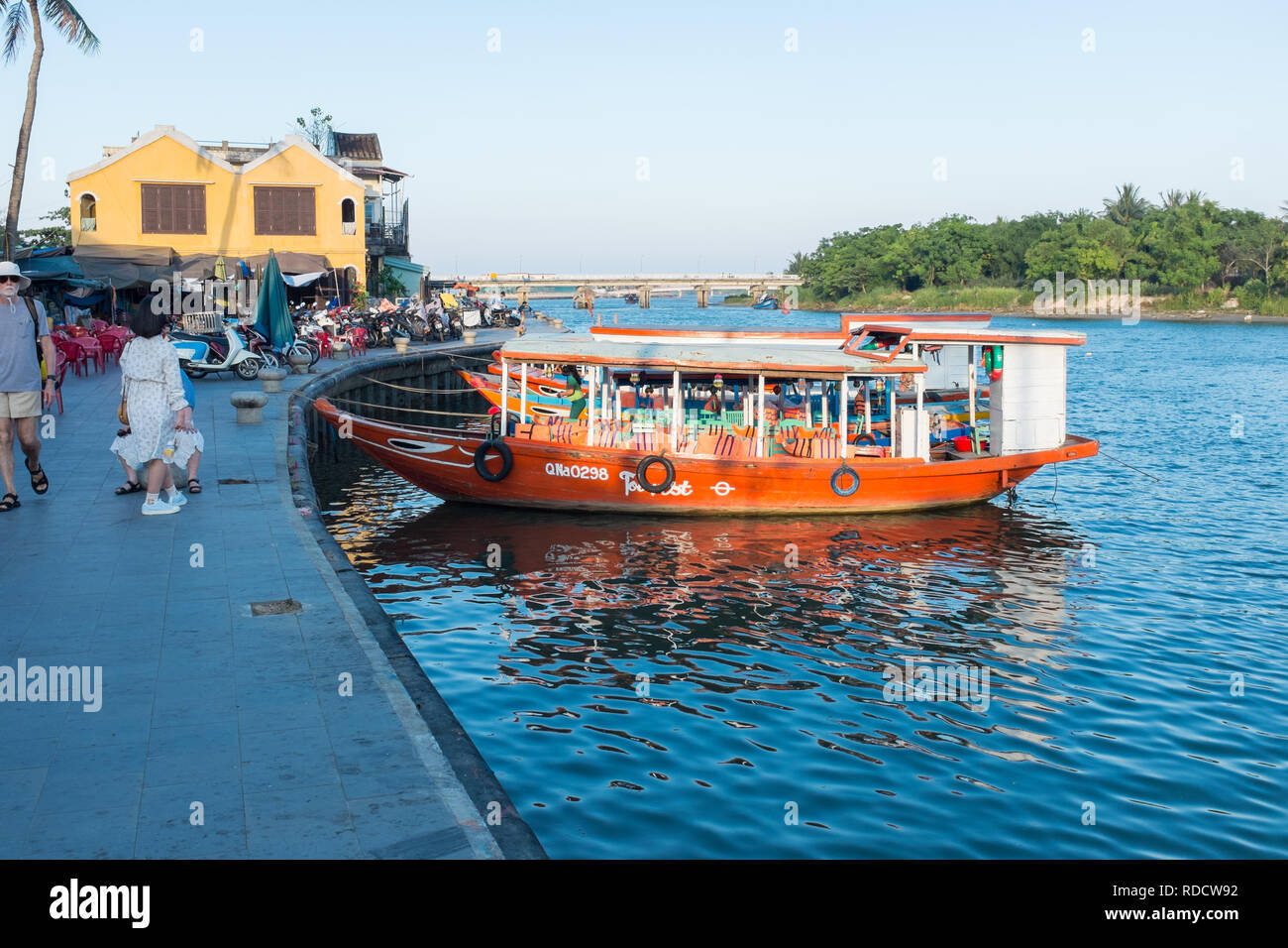 Tourist ferry boats moored on the riverbank in the Vietnamese city of Hoi An in Quang Nam Province Stock Photo
