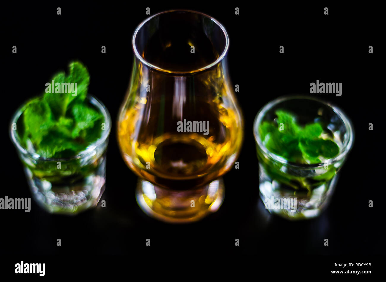 single malt whiskey in a glass and green mint liqueur, refreshing set